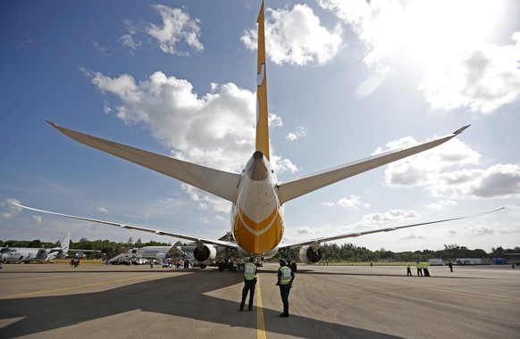 epa08654880 (FILE) - Two security guards stand under the tail section of a Scoot Boeing 787 Dreamliner commercial jet on display at the Singapore Airshow, 16 February 2016 (reissued 08 September 2020) ...