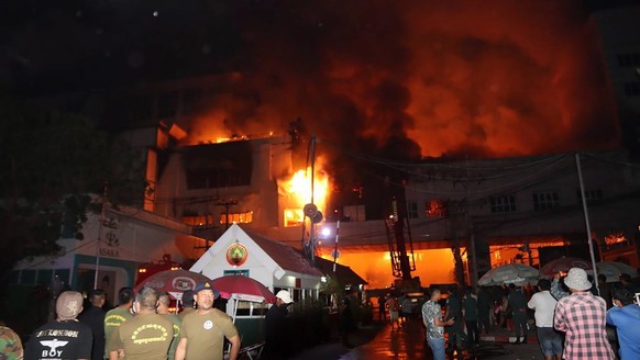 epa10381184 Firefighters at the scene of a major fire burning through the Grand Diamond City hotel-casino in Poipet, Banteay Meanchey province, Cambodia, 29 December 2022. At least 10 people were kill ...