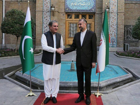 epa09546908 A handout picture made available by the Iranian foreign ministry office shows, Iranian Foreign Minister Hossein Amir-Abdoulahian (R) greets his Pakistani counterpart Shah Mahmood Qureshi ( ...