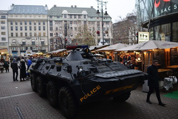 epa05683617 A passer-by walks past an armoured vehicle of the Counter Terrorism Centre of the Hungarian police standing guard at a Christmas market in downtown Budapest, Hungary, 20 December 2016. Sec ...