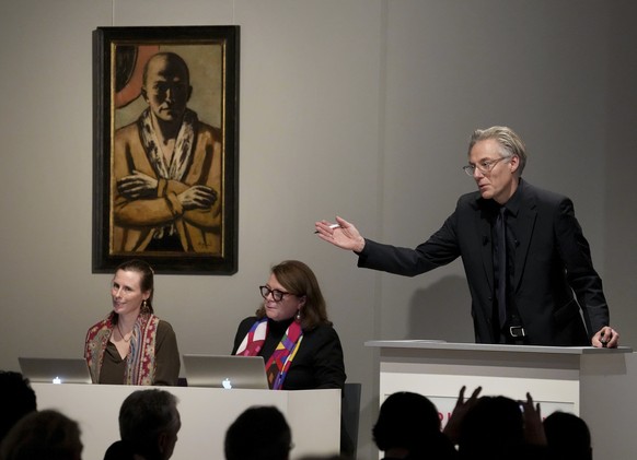 Auctioneer Markus Krause gestures in front of the painting &#039;Selbstbildnis gelb-rosa&#039; (self-portrait yellow-rose), 1943 oil on canvas, by German painter Max Beckmann, as it is auctioned in Be ...