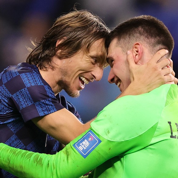 epaselect epa10350104 Luka Modric (L) of Croatia celebrates with his goalkeeper Dominik Livakovic after winning the penalty shoot-out of the FIFA World Cup 2022 round of 16 soccer match between Japan  ...