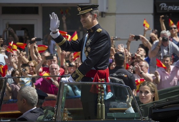 epa04266625 Spain&#039;s new King Felipe (C) and Queen Letizia (R) wave to the crowd on their way to the Royal Palace in a Rolls Royce Phantom IV convertible vintage car after his official proclamatio ...