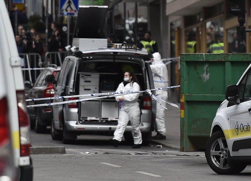epa05896916 Swedish forensic police investigators work at the crime scene in central Stockholm, Sweden, 08 April 2017. A truck was driven into a department store on Drottninggatan street (Queen Street ...