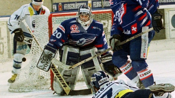 Eishockey NLA Spiel Ambri gegen Kloten, vom Sonntag, 4. Februar 2001. Der Ambri Angreifer Manuele Celio (vorne) verschiesst einen Angriff gegen den Klotener Torhueter Reto Pavoni und Oscar Szczepaniec ...