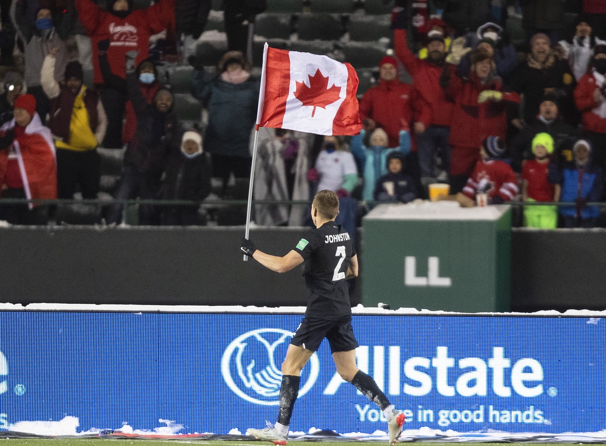 Canada's Alistair Johnston (2) parades the flag to celebrate the team's win over Mexico during a World Cup soccer qualifying match in Edmonton, Alberta, Tuesday, Nov. 16, 2021. (Jason Franso ...
