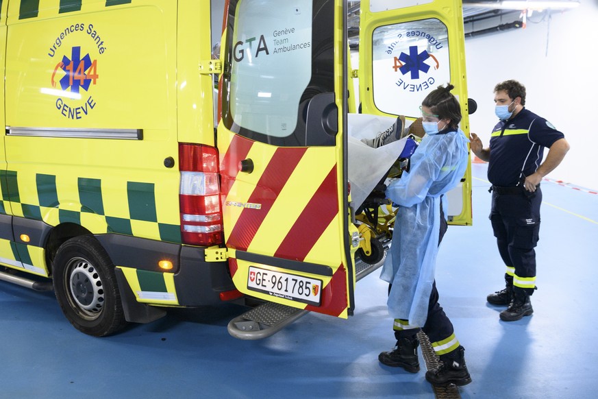 epa08827424 Paramedics unload a stretcher with a potential COVID-19 patient from an ambulance at the Geneva University Hospitals (HUG), during the coronavirus disease (COVID-19) pandemic, in Geneva, S ...