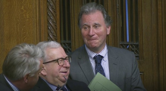 Oliver Letwin, right, listens as Prime Minister Boris Johnson delivers a statement to lawmakers inside a crowded House of Commons in London, Saturday Oct. 19, 2019. At a rare weekend sitting of Parlia ...