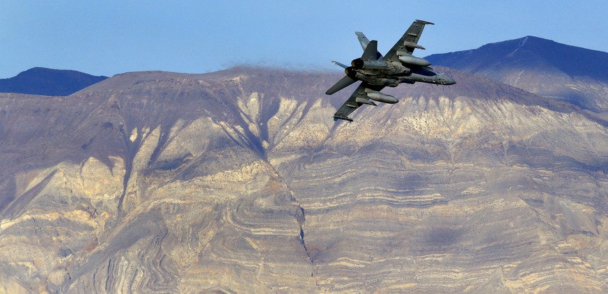 FILE - In this Feb. 27, 2017 file photo, an F/A-18D Hornet from the VX-9 Vampire squadron at Naval Air Weapons Station China Lake, flies out of what is known as Star Wars Canyon toward the Panamint ra ...