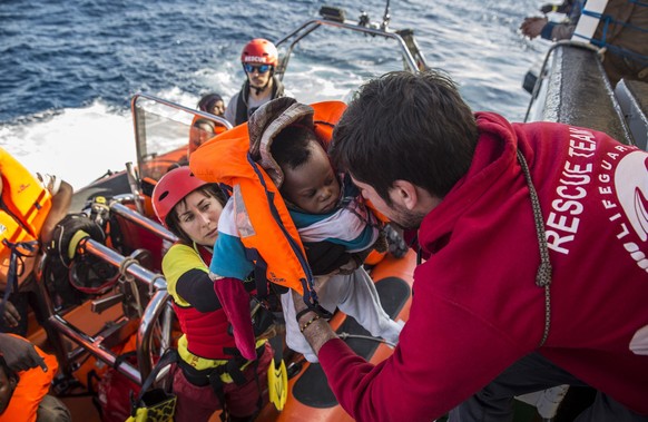 FILE - In this Friday, Dec. 21, 2018 file photo, a baby is loaded into the rescue vessel of the Spanish NGO Proactiva Open Arms, after being rescued in the Central Mediterranean Sea at 45 miles (72 ki ...