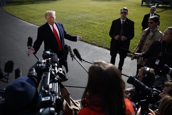 epa07197464 US President Donald J. Trump (C) responds to a question from the news media as he walks to board Marine One on the South Lawn of the White House in Washington, DC, USA, 29 November 2018. P ...