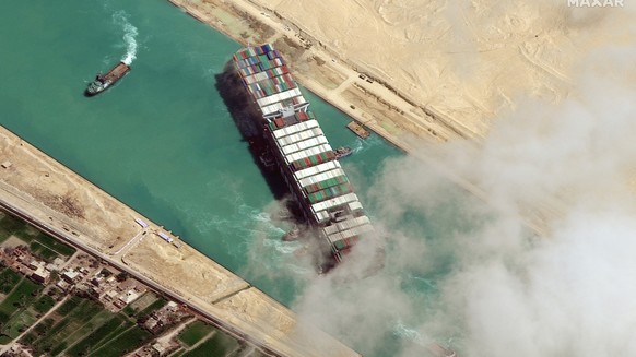 epa09105221 A handout satellite image made available by MAXAR Technologies shows , the Ever Given container ship after it has been moved away from the eastern bank of the canal and tugboats trying to  ...