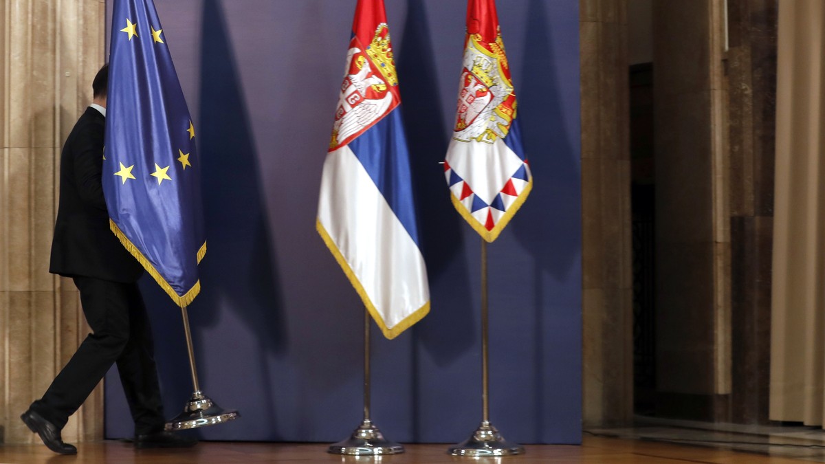 FILE - A protocol staff member carries the EU flag before the press conference of U.S. President Donald Trump's envoy for the Kosovo-Serbia dialogue, Ambassador Richard Grenell and Serbian Presid ...
