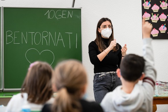 Die Lehrerin der ersten Klasse der Grundschule von Chiasso erklaert den Kindern den obligatorischen Gebrauch der Maske in der Schule, die ab heute im Kanton Tessin vorgeschrieben ist, am Montag, 10. J ...