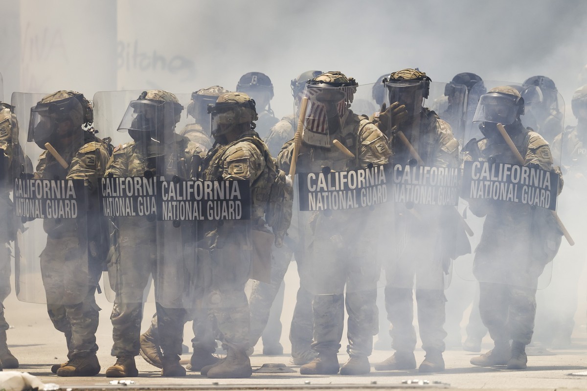 epa12164940 Members of the California National Guard seen through clouds of tear gas in front of the Edward R. Roybal Federal Building in Los Angeles, California, USA, 08 June 2025. US President Donal ...