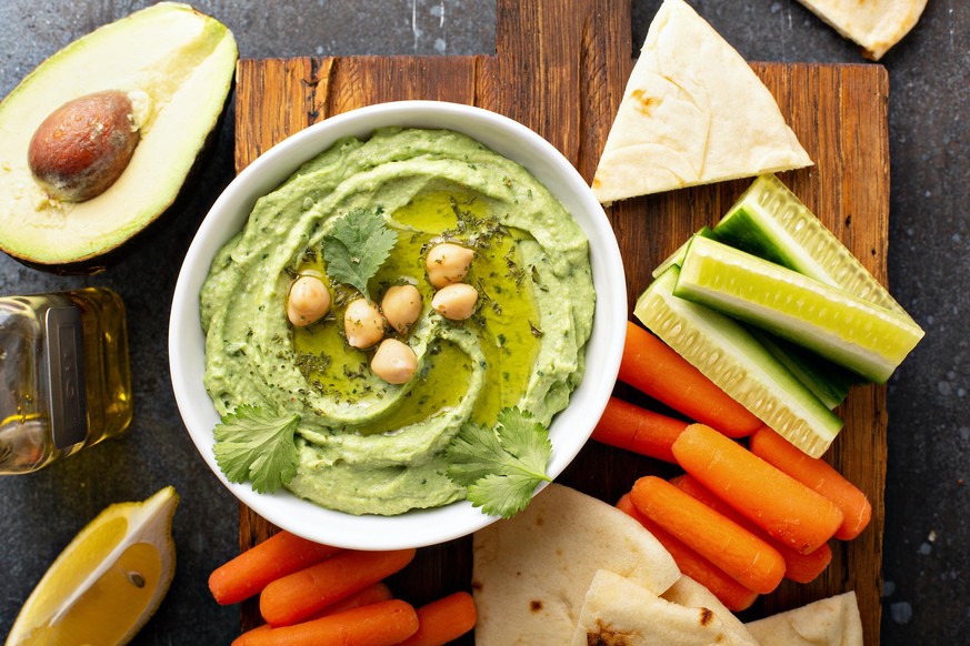 Homemade avocado cilantro hummus with flatbread and vegetables