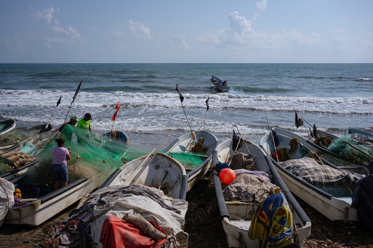 Fishermen untangle a net after suspending fishing trips because of an oil spill in the Gulf of Mexico that authorities said originated from an unidentified vessel and two natural oil seeps in Salinas, ...