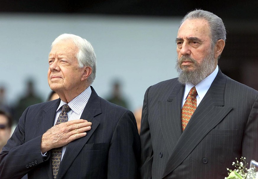 Former US president Jimmy Carter (L) and Cuban President Fidel Castro listen to US National Anthems after Carter&#039;s arrival at the Jose Marti airport in Havana 12 May 2002. Carter is the first US  ...