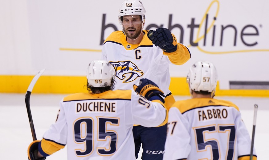 Nashville Predators defenseman Roman Josi, rear, celebrates with center Matt Duchene (95)ref52 and defenseman Dante Fabbro (57) after Josi scored during the second period of an NHL hockey game against ...