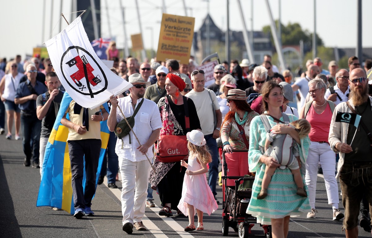 epa08684068 Demonstrators carry placards as they march during a protest against coronavirus pandemic restrictions and regulations in Duesseldorf, Germany, 20 September 2020. The initiative 'Querd ...