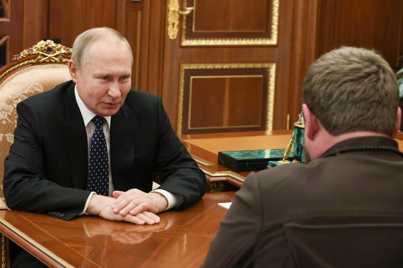 Russian President Vladimir Putin listens to Chechnya regional leader Ramzan Kadyrov back to a camera during their meeting at the Kremlin in Moscow, Russia, Monday, March 13, 2023. (Mikhail Kl…