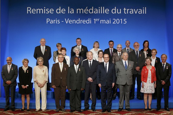 French President Francois Hollande (4thR) and Minister of Labour Francois Rebsamen (5thR) pose with people who received Working Medal of Honor awards at a ceremony on May Day at the Elysee Palace, in  ...