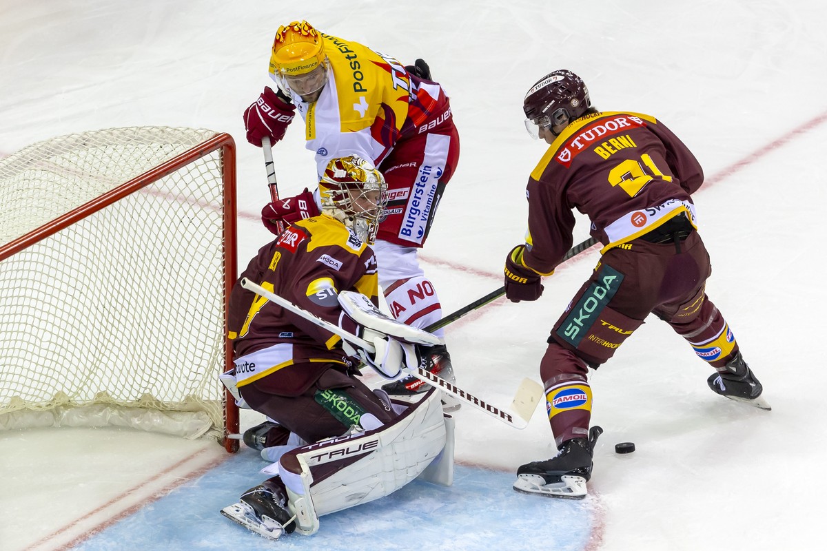PostFinance Top Scorer Nicklas Jensen (SCRJ), left, vies for the puck with goaltender le gardien Robert Mayer (GSHC), centre, and Tim Berni (GSHC), right, during a National League regular season game  ...
