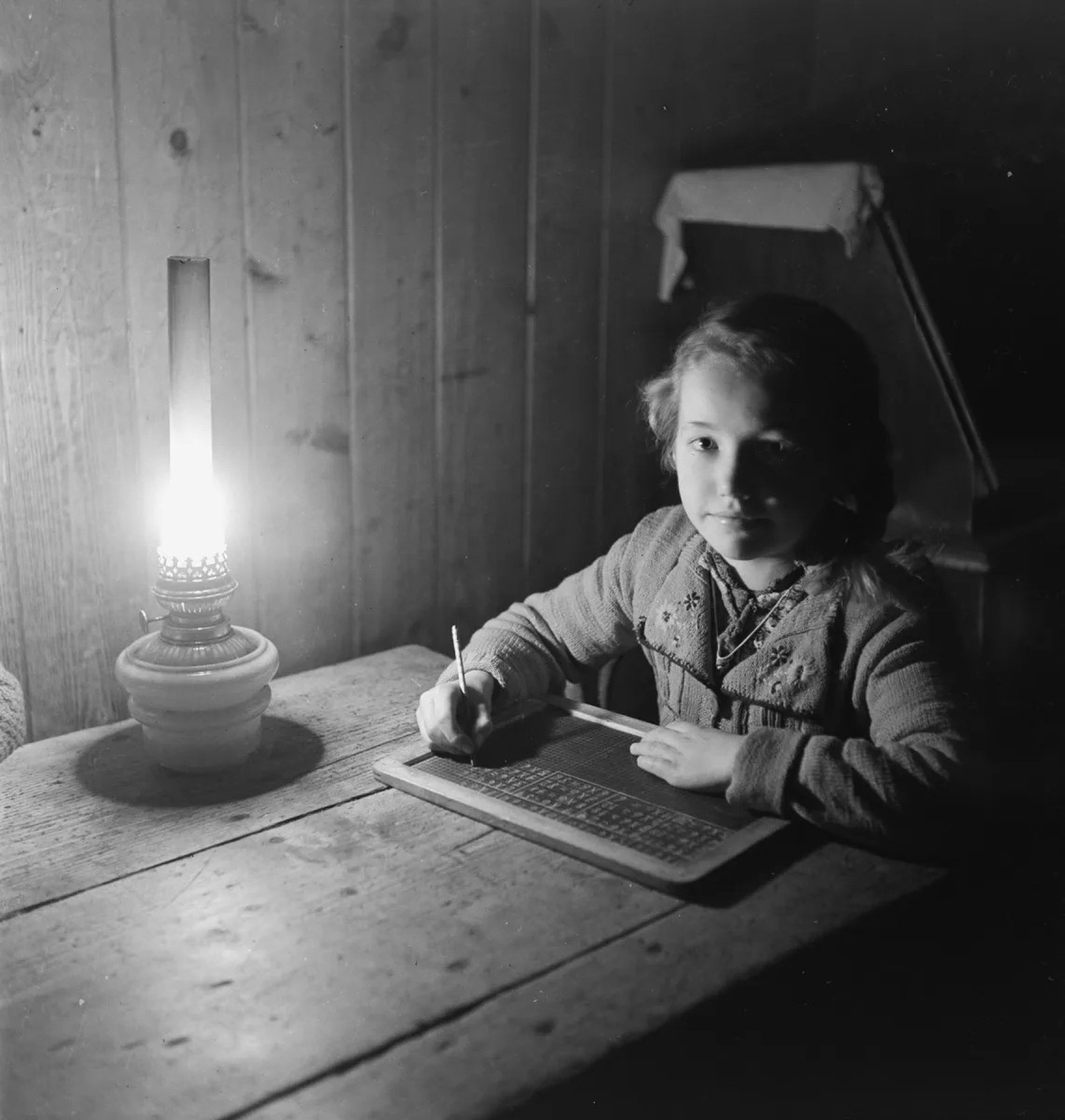 Ein Mädchen schreibt mit Griffel auf eine Schiefertafel, 1930-1950.
https://dls.staatsarchiv.bs.ch/records/1675860