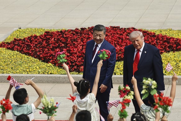 epa12955678 Children hold Chinese and U.S. flags as U.S. President Donald Trump participates in a welcome ceremony with Chinese President Xi Jinping at the Great Hall of the People in Beijing, China,  ...