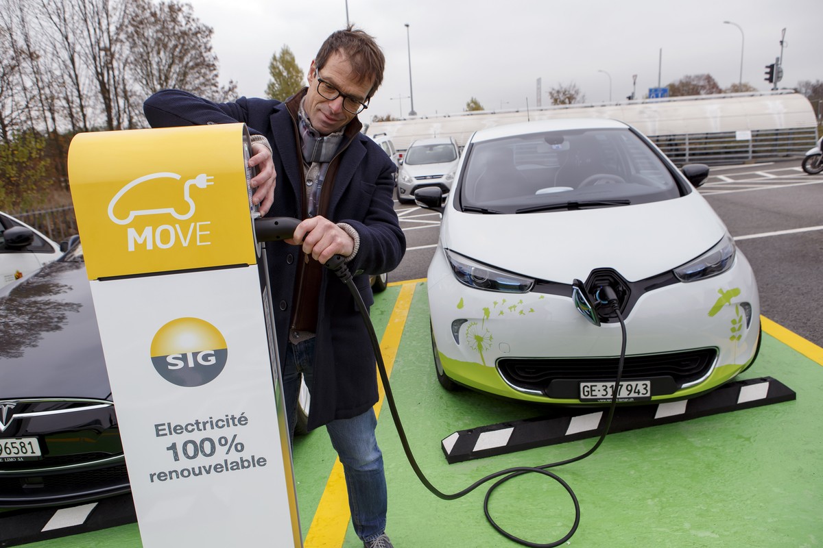 Un homme branche sa voiture electrique a une borne electrique de recharge rapide du parking P+R Bernex, lors d'une presentation a la presse, ce lundi, 14 novembre 2016, a Bernex pres de Geneve. ( ...