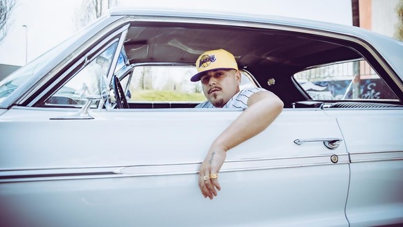 CH-Rapper Arber Rama alias EAZ, wie er sich auf seiner Webseite präsentiert im Auto sitzend
