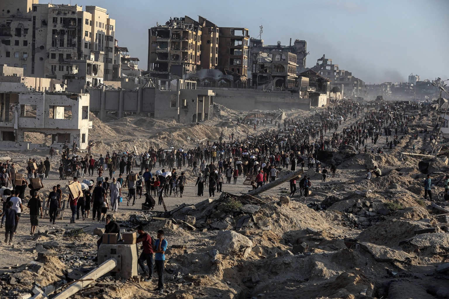 Palestinians carry food parcel, distributed by Gaza Humanitarian Relief Foundation as people struggle with hunger during ongoing Israeli attacks in Gaza City Palestinians carry food parcel, distribute ...