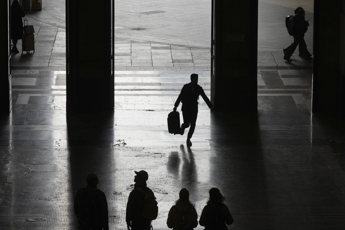 People walk at the train station during a nationwide transport strike, in Milan, Italy, Friday, Nov. 8, 2024. (AP Photo/Antonio Calanni)