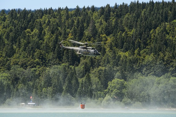 Un helicoptere Super Puma de l&#039;Armee suisse prends de l&#039;eau dans le lac de Joux pour abreuver les vaches d&#039;un paysan lors d&#039;un point presse sur le dispositif secheresse ce mardi 21 ...