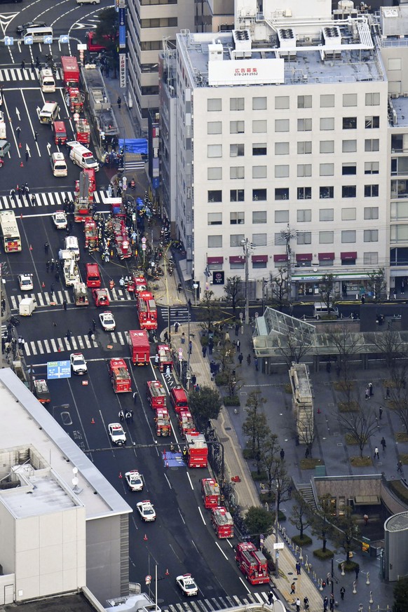 Fire engines park near a building where a fire broke out in Osaka, western Japan Friday, Dec. 17, 2021. Dozens of people are feared dead after a fire broke out in the building, fire department officia ...