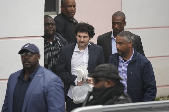 FTX founder Sam Bankman-Fried, center, is escorted from the Magistrate Court in Nassau, Bahamas, Wednesday, Dec. 21, 2022, after agreeing to be extradited to the U.S. (AP Photo/Rebecca Blackwell)
Sam  ...