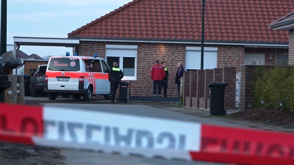 March 1, 2024, Lower Saxony, Bothel: Emergency services stand behind a barrier tape.  The police are investigating possible capital crimes after shots were fired in the Rotenburg district.  There are two crime scenes - one...