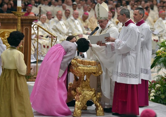 Papst Franziskus tauft eine Frau aus Südkorea.