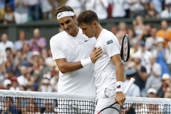 Roger Federer of Switzerland, left, and Dusan Lajovic of Serbia, shake hands after their second round match at the Wimbledon Championships at the All England Lawn Tennis Club, in London, Britain, 06 J ...