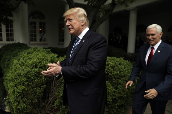 FILE - In this May 4, 2017, file photo, President Donald Trump claps as he arrives in the Rose Garden of the White House in Washington, followed by Vice President Mike Pence after the House pushed thr ...