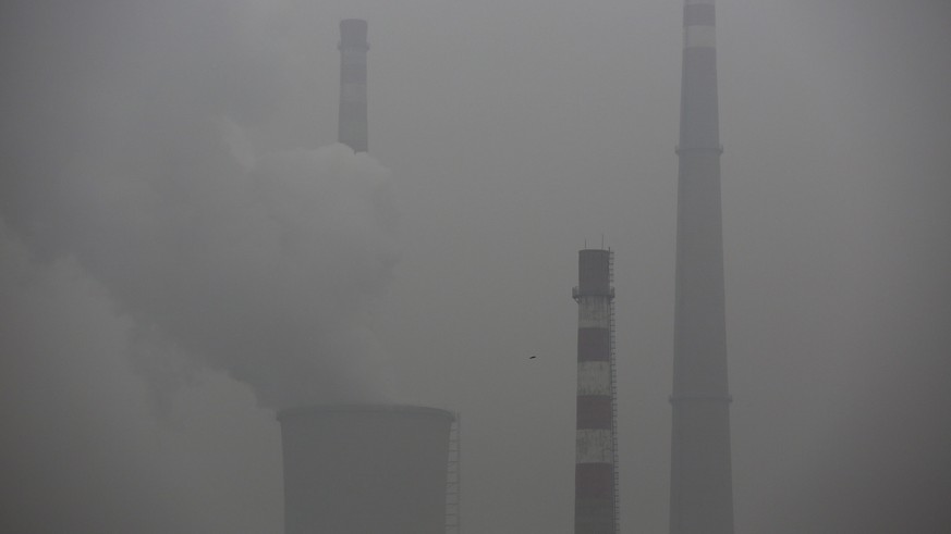 epa05021605 Smoke and steam from chimneys of a power plant during a haze day in Beijing city, China, 12 November 2015. Heavy smog continue to hang over the northern and northeastern China. The Beijing ...