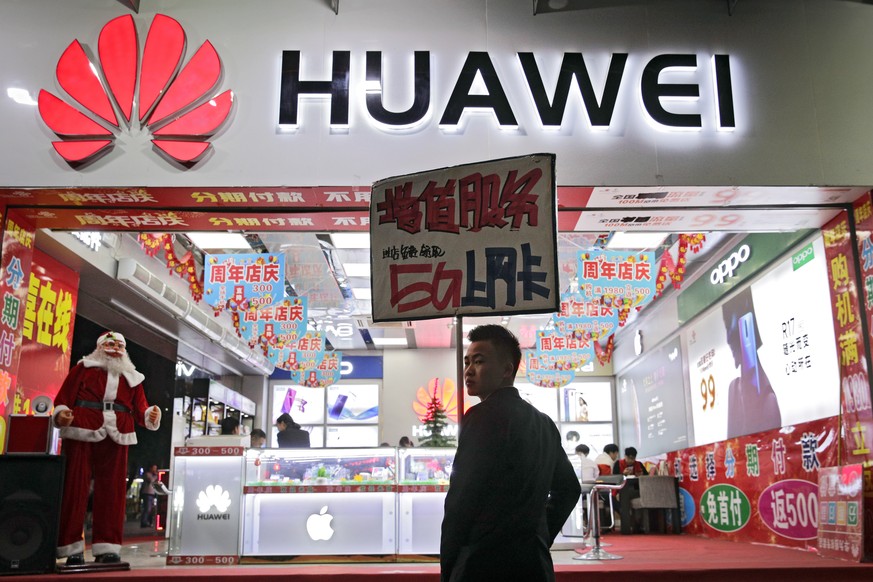 FILE - In this Dec. 18, 2018, file photo, a worker holds a sign promoting a sale for Huawei 5G internet services at a mobile phone retail shop in Shenzhen in south China&#039;s Guangdong province. Chi ...