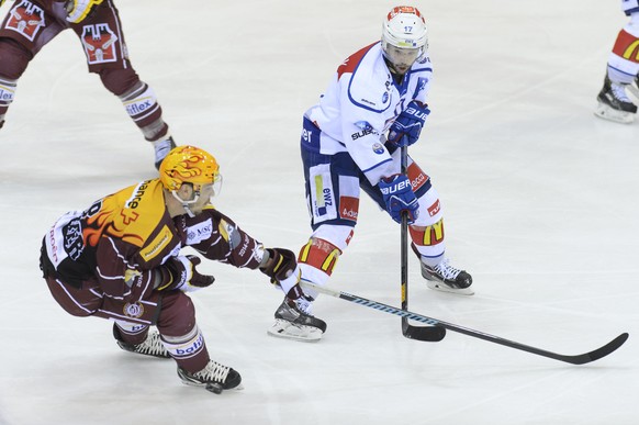 Le joueur zurichois, Ryan Shannon, droite, a la lutte pour le puck avec le joueur Genevois, Matt D'Agostini, gauche, lors du 2eme match des demi-finales de play off du championnat suisse de hockey sur glace de National League LNA, entre le Geneve Servette HC et le ZSC Lions, ce jeudi 19 mars 2015 a la patinoire des Vernets a Geneve. (PHOTOPRESS/Martial Trezzini)