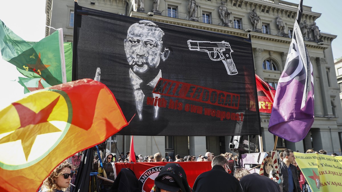 epa05870520 A banner reads; 'Kill Erdogan with his own weapons', as protesters march during a demonstration against the Turkish President Recep Tayyip Erdogan, in Bern, Switzerland, 25 March ...