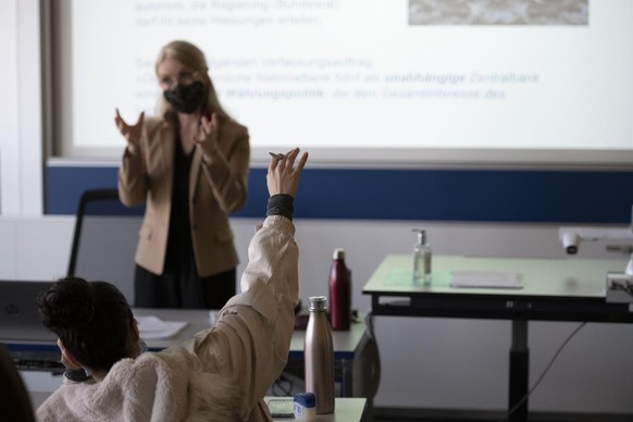 Ein Schueler der Klasse 21-M2.22 streckt auf waehrend der Wirtschaft und Gesellschafts-Unterrichts an der der Wirtschaftsschule KV Zuerich auf, fotografiert am 25. Maerz 2021 in Zuerich. (KEYSTONE/Chr ...