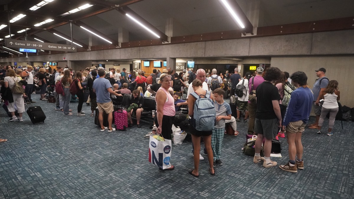 People gather while waiting for flights at the Kahului Airport Wednesday, Aug. 9, 2023, in Kahului, Hawaii. Several thousand Hawaii residents raced to escape homes on Maui as the Lahaina fire swept ac ...