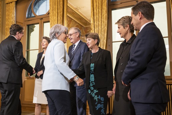 Die neugewaehlten Mitglieder des Bundesrats, Albert Roesti, links, und Elisabeth Baume-Schneider, 3. von links, werden von ihren neuen KollegInnen, von rechts, Bundeskanzler Walter Thurnherr, Karin Ke ...