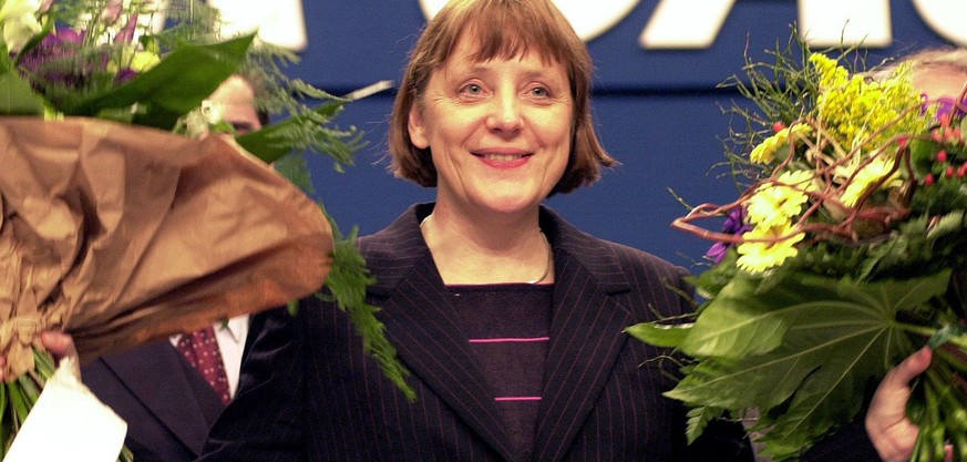 ARCHIV - 10.04.2000, Nordrhein-Westfalen, Essen: Nach ihrer Wahl zur neuen Vorsitzenden der CDU bedankt sich Angela Merkel bei den Delegierten des CDU-Bundesparteitages und winkt mit zwei Blumenstraeu ...