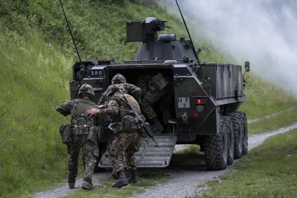 Soldaten des Gebirgsinfanterie Bataillon 29 der Schweizer Armee ziehen sich zurueck mit einem Piranha Radschuetzenpanzer 93, bei einem Gefechtsschiessen, aufgenommen am Dienstag, 27. Mai 2025, in Chur ...