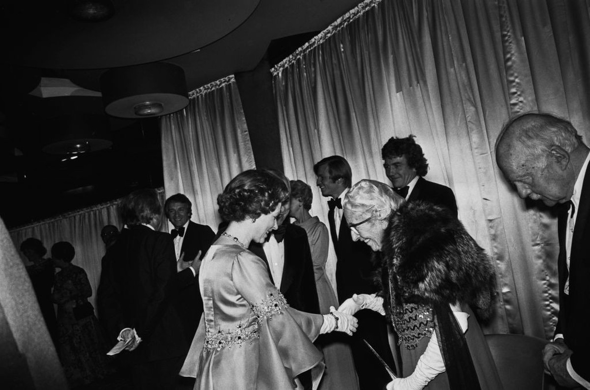 Queen Elizabeth II meets English author Dame Agatha Christie (1890 - 1976) and her husband Sir Max Mallowan (1904 - 1974, right) at the Royal World Premiere of the film 'Murder on the Orient Expr ...